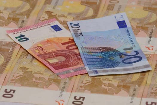 One ten and one twenty euro notes are on several tens of euro notes