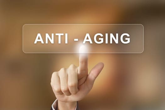 business hand pushing anti aging button on blurred background