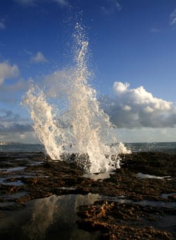 blow hole on Cadiz coastline sending two burst of water high into the air, Spain