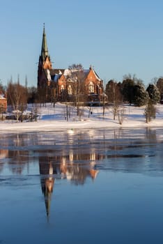 Church in Umeå, Sweden with clear blue sky and some ice on the river.