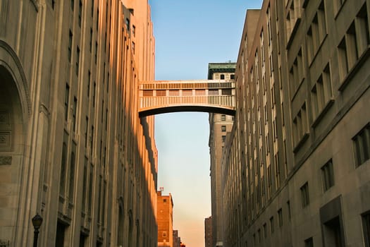 A walkway connecting two office buildings high above the street. Sunset
