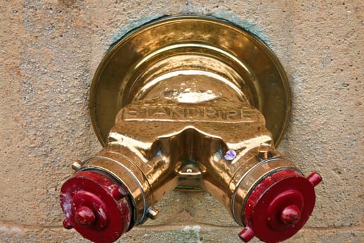 Golden standpipe on a New York City wall