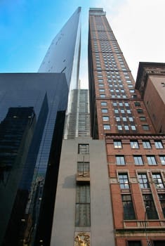 Two skyscrapers of different materials are proudly standing under the New York sun