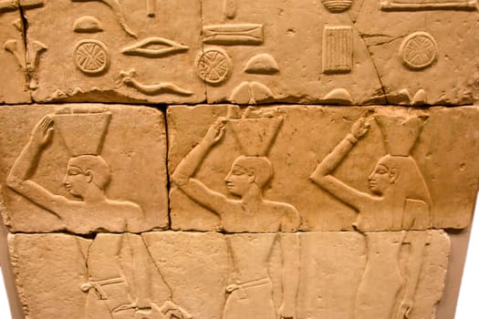 Egyptian relief with three offering people. They transport goods on their heads