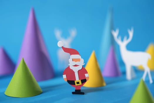 Merry Christmas 3d paper cut design with handmade santa, Xmas pine tree shapes and deer silhouettes. Ideal for holiday greeting card, poster or web.    .