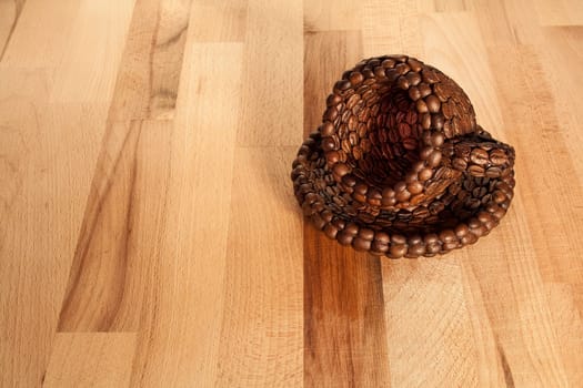 Close up view of a cup covered with coffee beans on a wooden surface