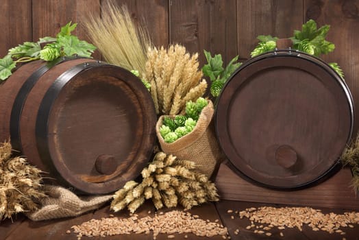 Two beer barrels with wheat,barley,hops and malt