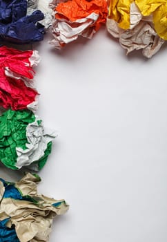 crumpled colorful paper and white paper card  on wooden background, place for tex