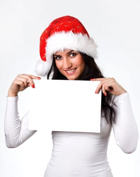 beautiful girl in a Santa Claus hat with a clean sheet of paper on a white background