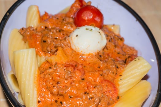 Rigatoni noodles with Bolognese sauce in a bowl..