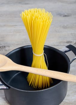 spaghetti packet in a black pan, ready for cooking