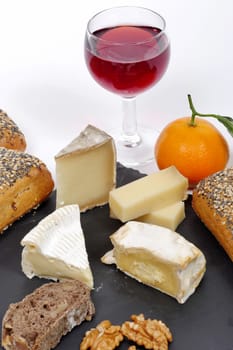 french cheese platter with a glass of red wine and mandarin