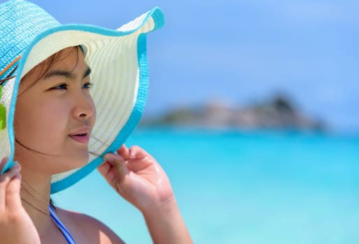 Face young woman wearing sun protection hat  is happy to see the beautiful nature of sea and beach under the summer sky at Koh Miang Island in Mu Ko Similan National Park, Phang Nga, Thailand