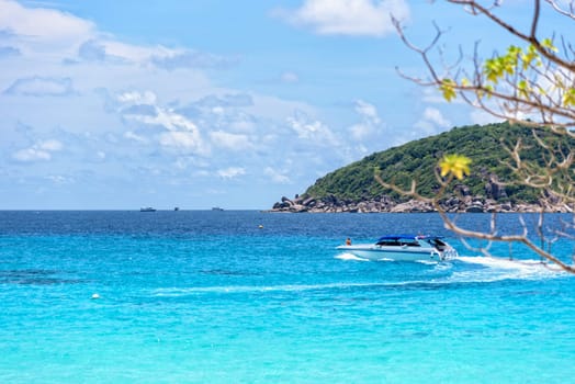 Beautiful landscape of blue sea and speed boat taking tourists traveling to Koh Miang Island under the summer sky for background in Mu Ko Similan National Park, Phang Nga Province, Thailand
