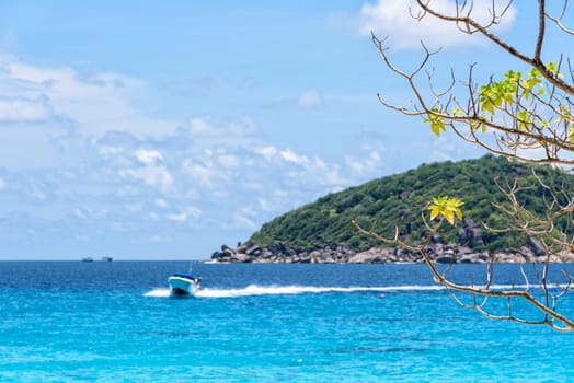 Beautiful landscape of blue sea and speed boat taking tourists traveling to Koh Miang Island under the summer sky for background in Mu Ko Similan National Park, Phang Nga Province, Thailand