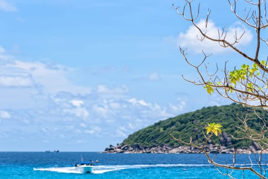 Beautiful landscape of blue sea and speed boat taking tourists traveling to Koh Miang Island under the summer sky for background in Mu Ko Similan National Park, Phang Nga Province, Thailand