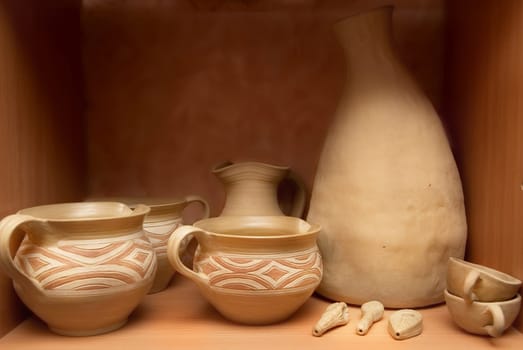 Many handmade old clay pots on the shelf.