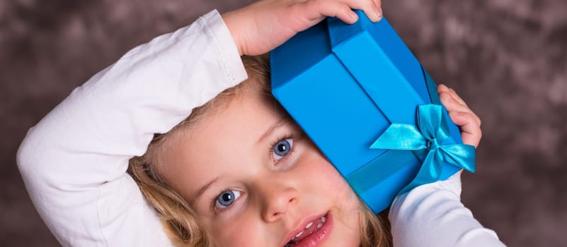 portrait of a sweet blond girl with blue present