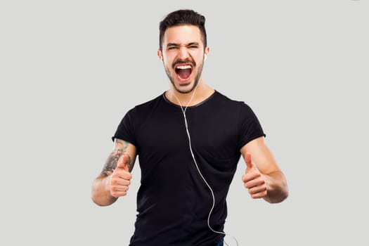 Beautiful and happy latin man listen music with thumbs up