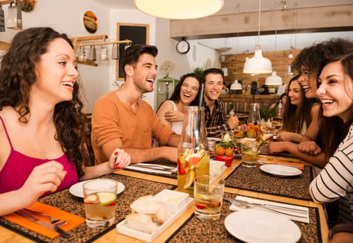 Multi-Ethnic Group of happy friends lunching and tasting the dessert at the restaurant