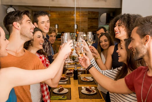 Group of friends toasting and looking happy at a restaurant