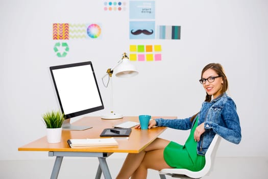 Woman working at desk In a creative office, using a computer