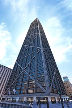 Skyscraper modern squared structure, with metal and glass, viewed from below with nice sky on background.