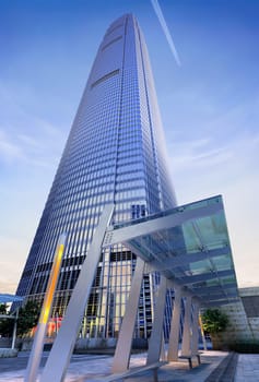 3D rendering of a generic Modern Skyscraper viewed from below, with bus shelter in the foreground.