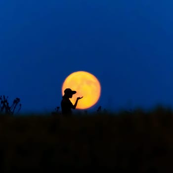 A woman with a hat in front of a full moon is happy
