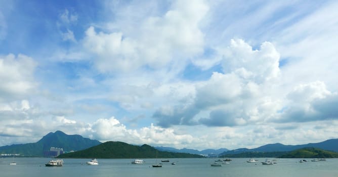 Boats, clouds, lake and blue sky in sunny day