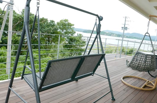 Outdoor swing chairs are on the wooden floor