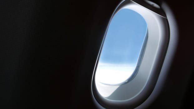 Airplane window with blue sky