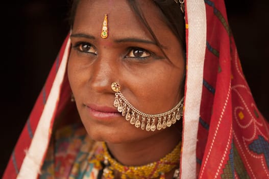 Close up portrait of thoughtful traditional Indian woman in sari dress, India people.