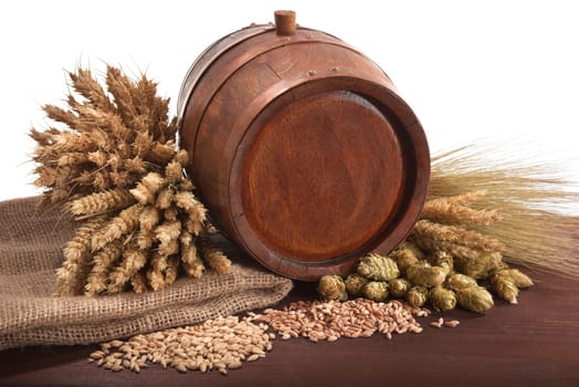 Old barrel with wheat,barley,hops and malt against a white background