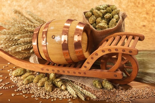 Old barrel with wheelbarrow,wheat,barley,hops and malt