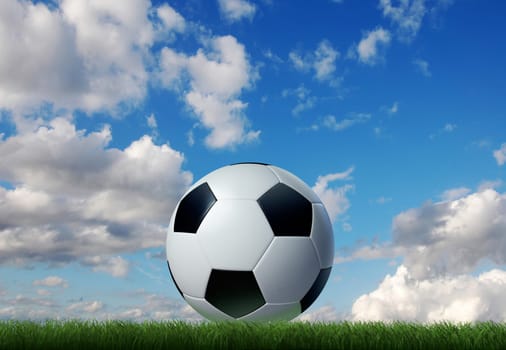 Football/soccer classic ball, on grass, with sky and clouds on the background.
