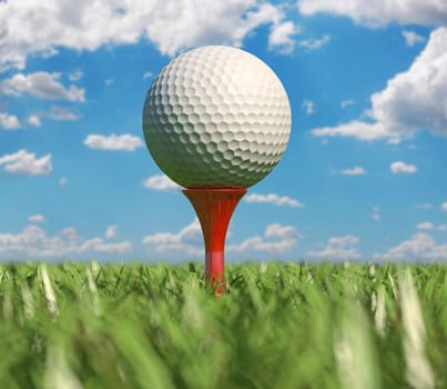 Golf ball isolated on tee in the grass, Close up, viewed from ground level with depth of field effect.