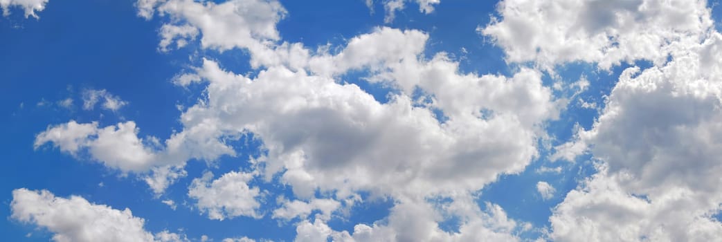 Blue sky with many cumulus white clouds. Cinemascope format.