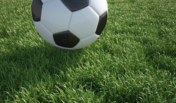 Soccer ball close up on grass lawn. The top part of the ball is cropped out of the scene.