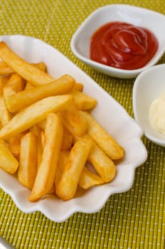 French fries in a white bowl with tomato sauce and mayonnaise