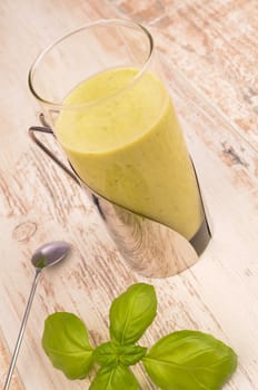 Green healthy smoothie on a rustic wooden table
