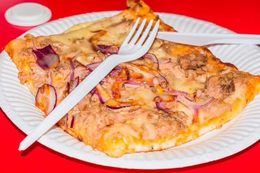 Pizza piece from a fast food restaurant in the city.