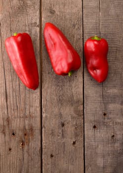 Fresh red paprika on a rustic wooden table with space for text