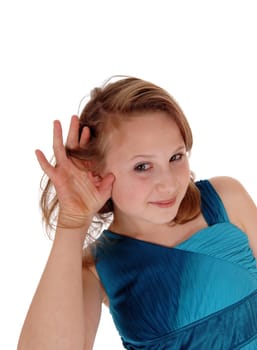 A blond young girl in a black dress with one hand behind her ear can not.hear well, isolated for white background..