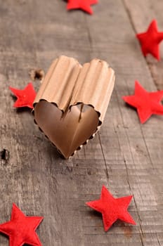 Love concept background with a heart shaped piece of cardboard on a rustic wooden table