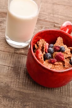 Muesli with organic milk on a rustic wooden table