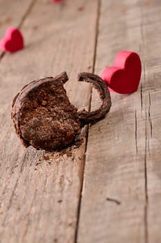 Rusty padlock with a red heart shape on a wooden background