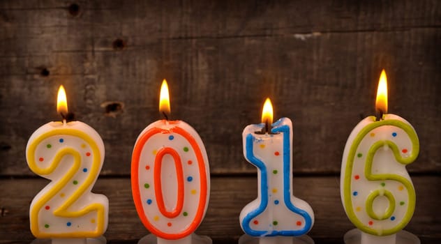 Colorful candles with number 2016 on a wooden background, New Year concept