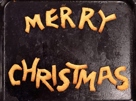 Sweet Merry Christmas cookies on an old used dirty baking plate