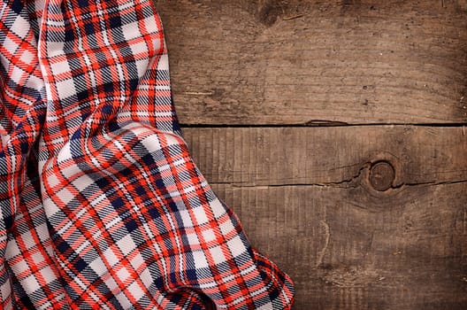 Checkered table cloth on a rustic wooden table with space for text or image